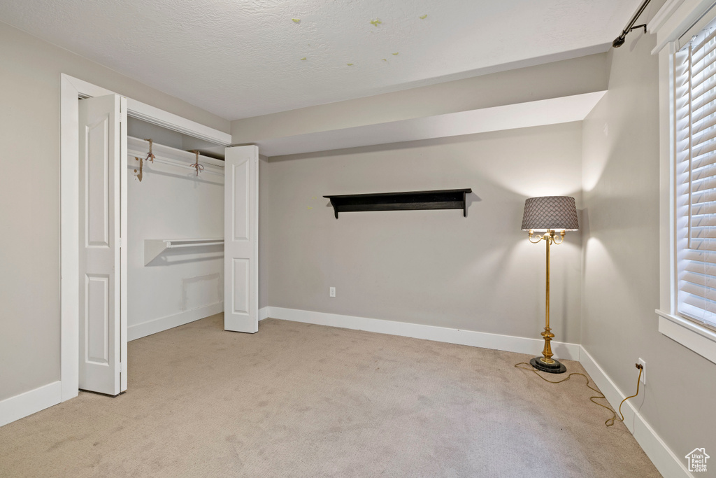 Unfurnished bedroom with light carpet