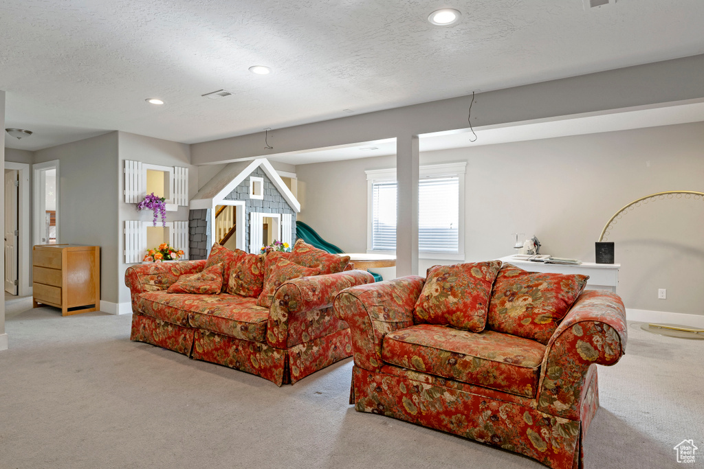 Living room featuring light carpet and a textured ceiling