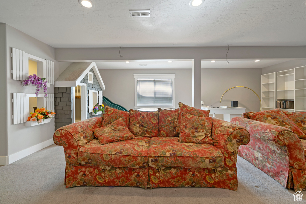 Living room featuring light colored carpet and a textured ceiling