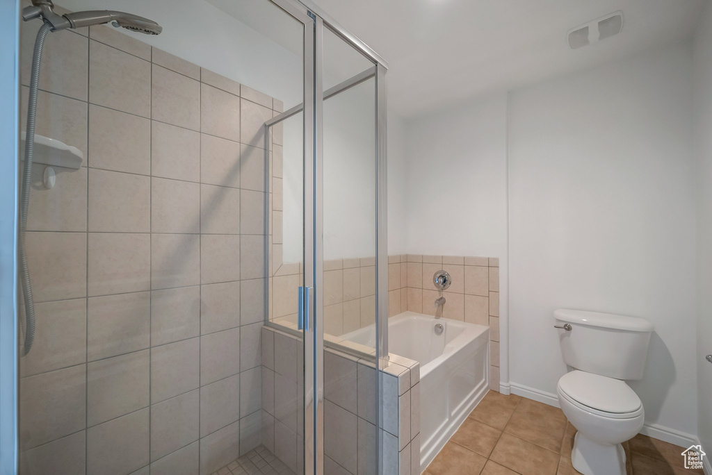 Bathroom featuring a bath, toilet, a shower stall, and tile patterned flooring