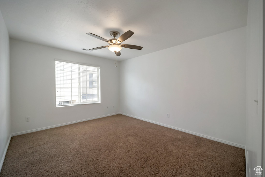 Unfurnished room with carpet flooring, a ceiling fan, and baseboards