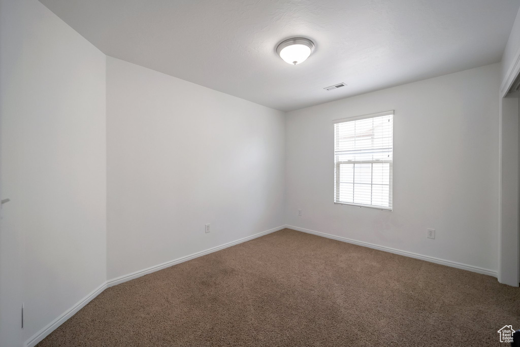 Carpeted empty room featuring baseboards