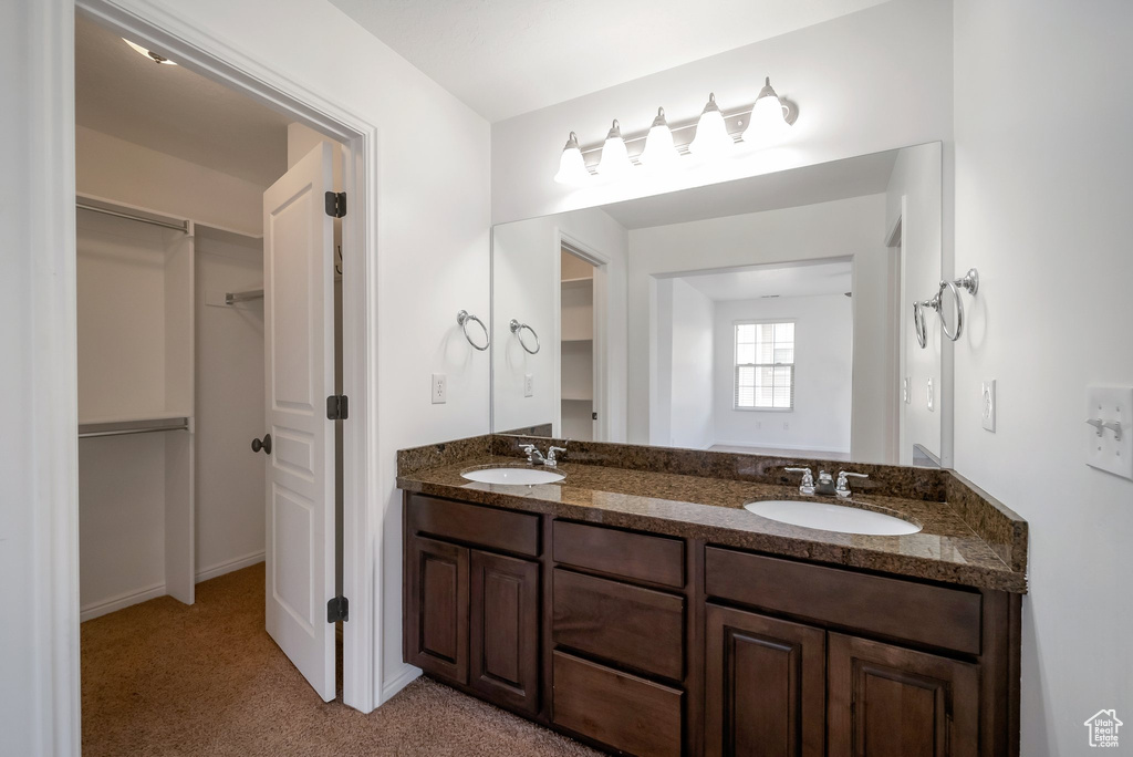 Full bath with double vanity and a spacious closet