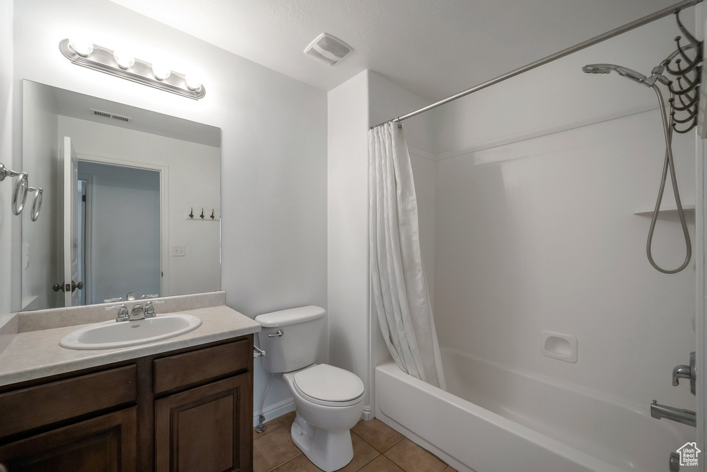 Bathroom with vanity, toilet, shower / bath combo, and tile patterned floors