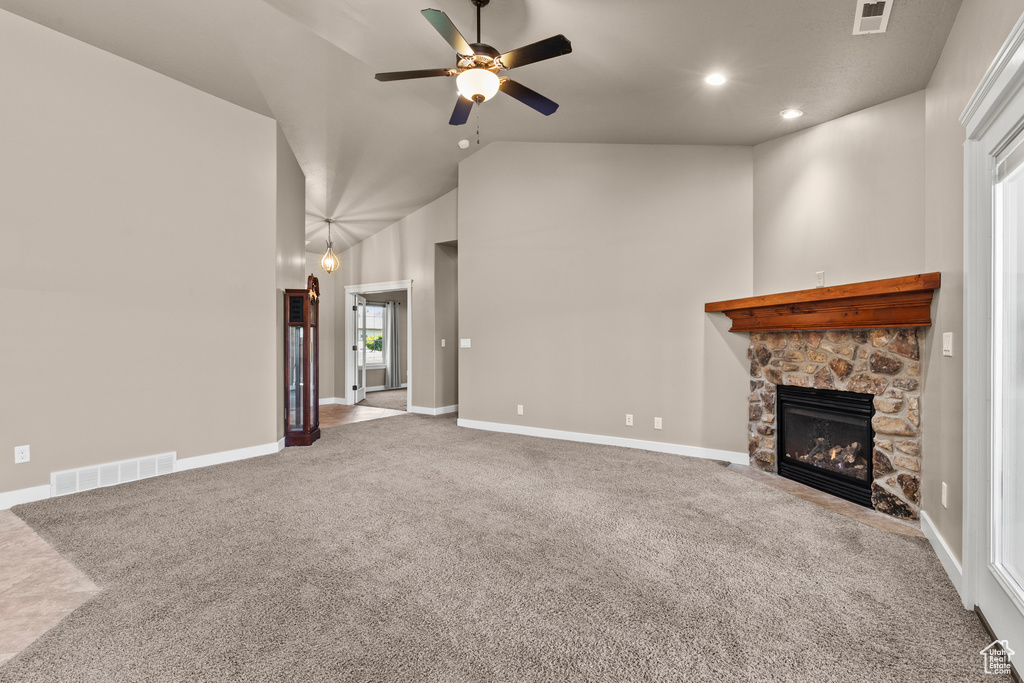 Unfurnished living room with carpet floors, a stone fireplace, ceiling fan, recessed lighting, and high vaulted ceiling