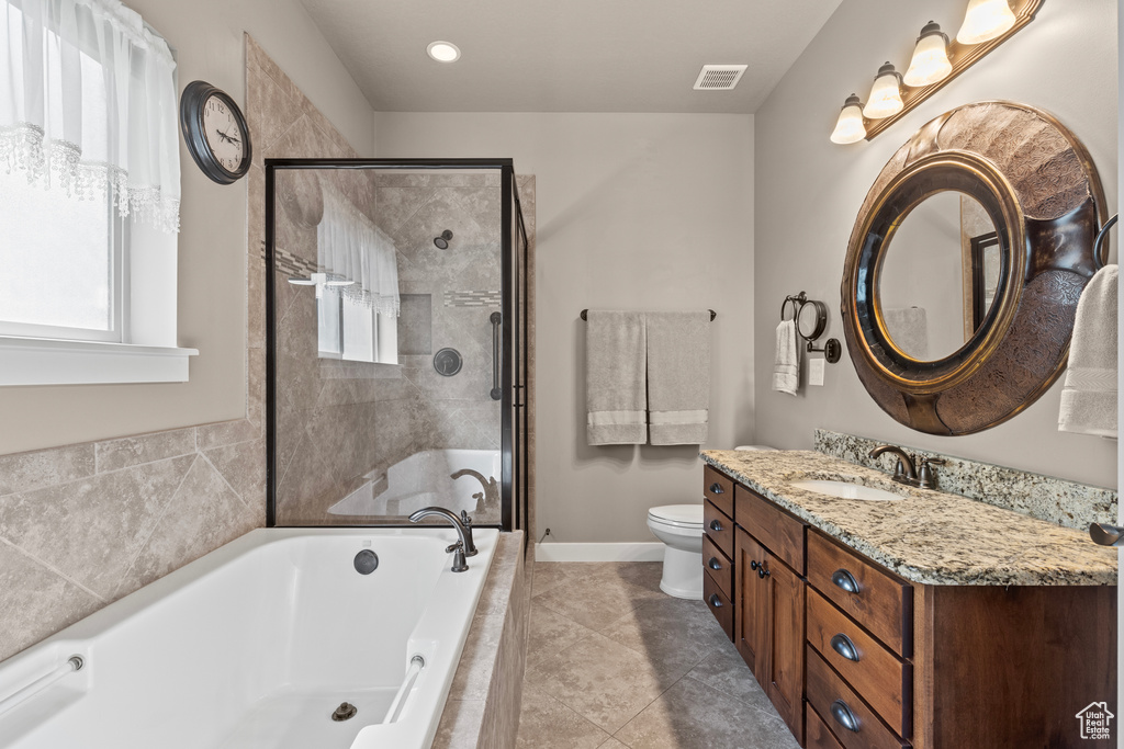 Full bathroom featuring a garden tub, vanity, a stall shower, toilet, and tile patterned floors