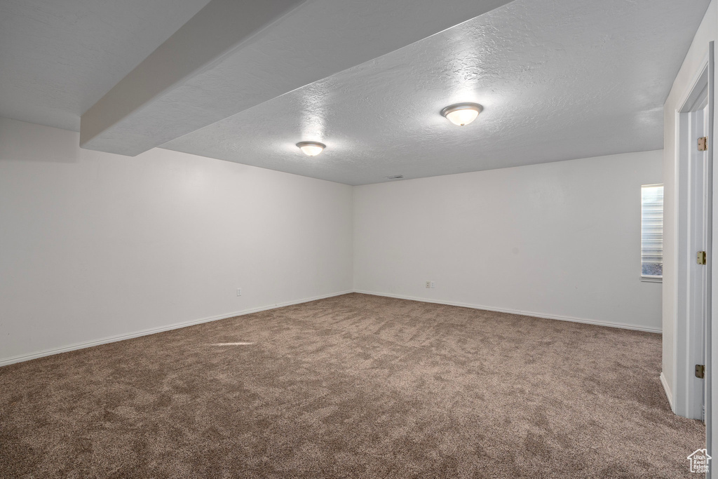 Spare room with a textured ceiling and carpet