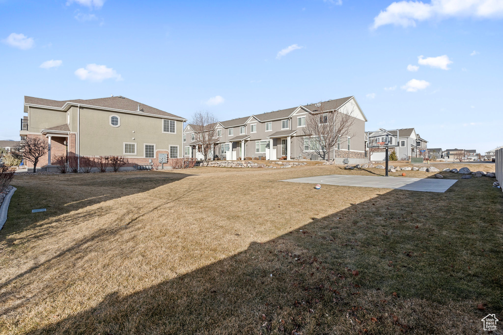 Rear view of house with a yard and basketball hoop