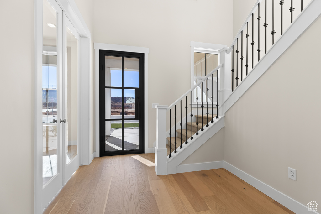 Entryway with light hardwood / wood-style flooring and a high ceiling