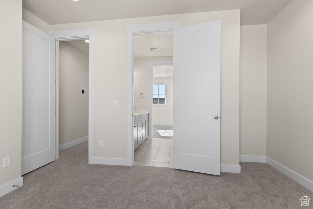 Unfurnished bedroom featuring light colored carpet