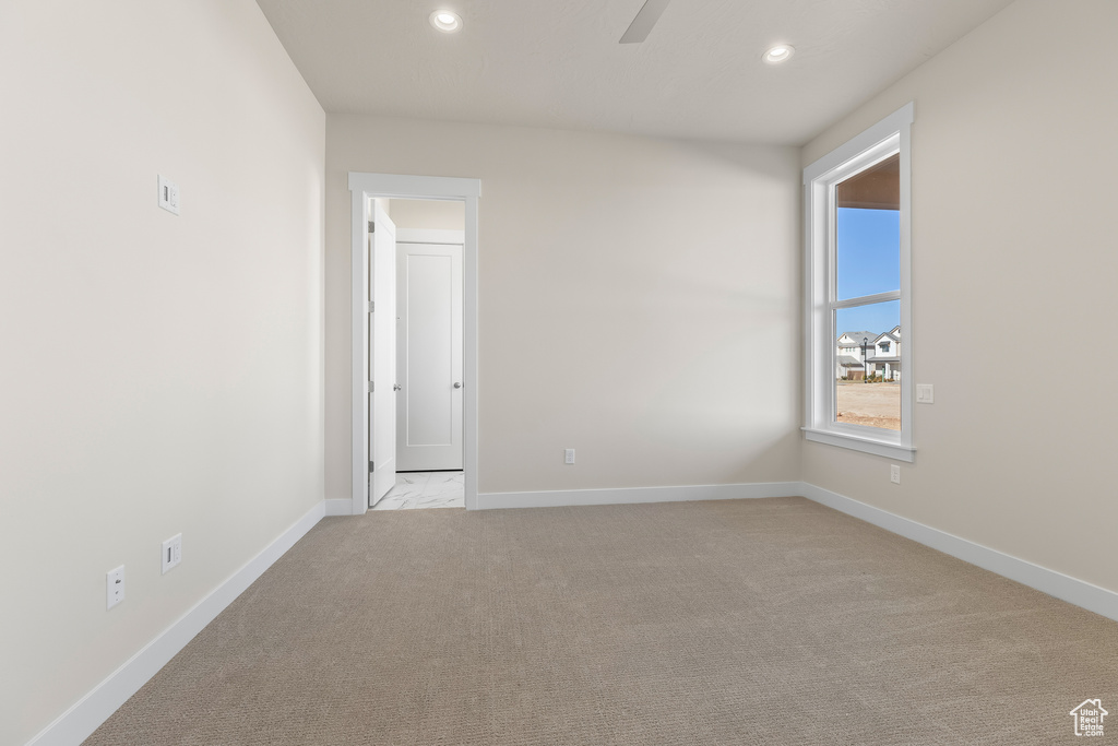 Carpeted empty room featuring ceiling fan