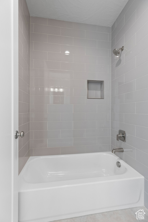 Bathroom featuring tile patterned flooring and tiled shower / bath combo