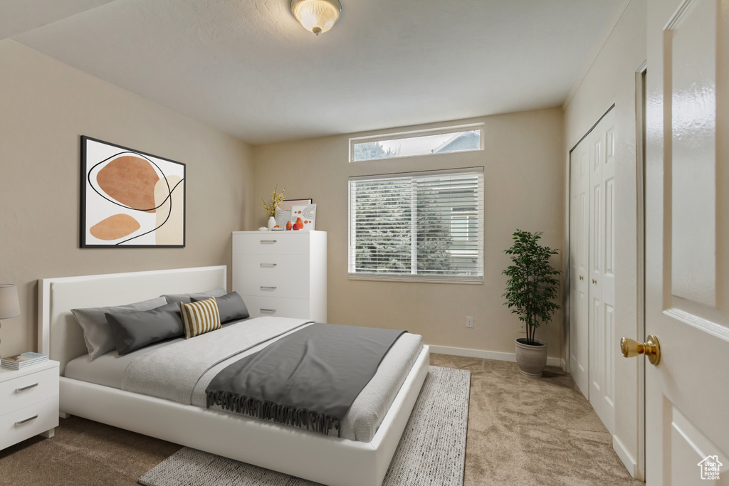 Carpeted bedroom with a closet and baseboards