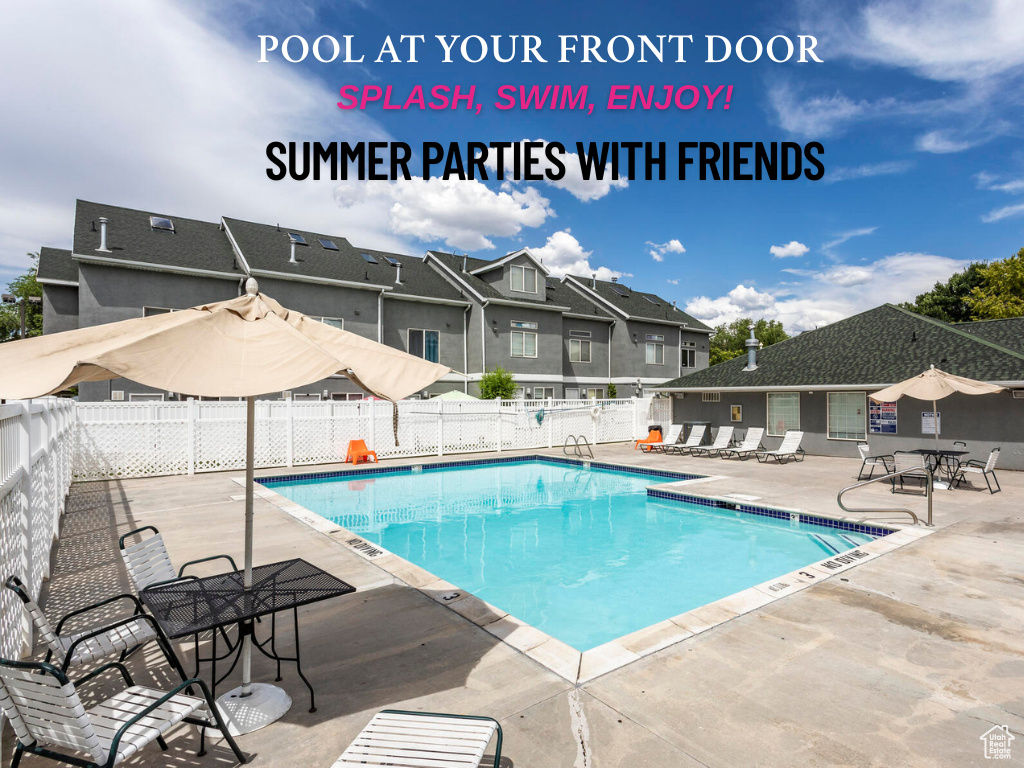 Community pool with fence, a patio, and a residential view