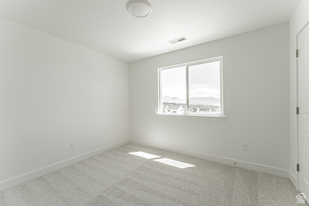 Carpeted empty room featuring baseboards