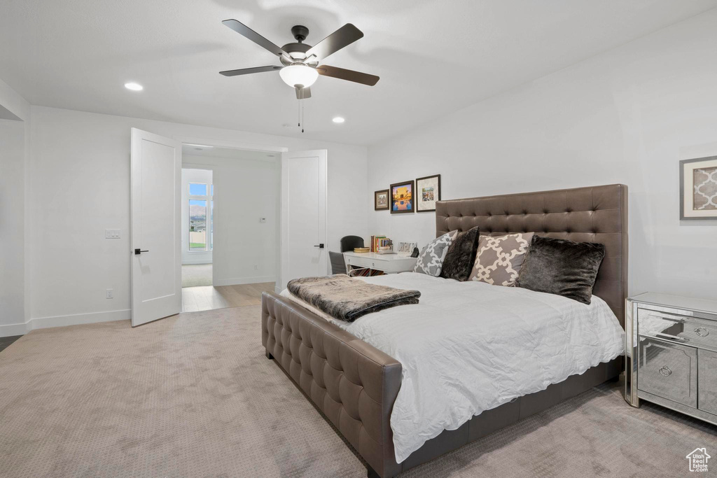 Bedroom with ceiling fan and light colored carpet
