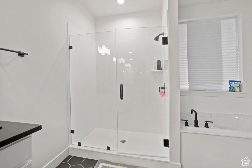 Bathroom featuring tile patterned floors, separate shower and tub, and vanity