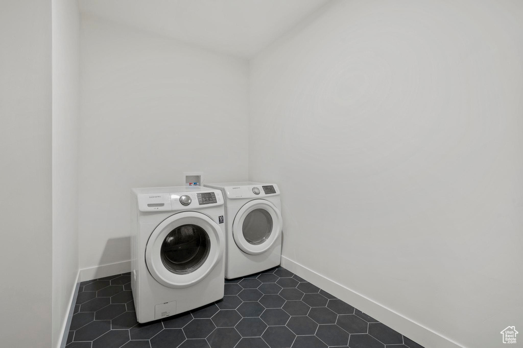 Washroom featuring separate washer and dryer and dark tile patterned flooring