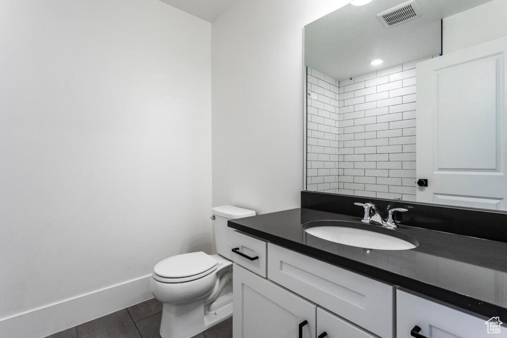 Bathroom featuring vanity, toilet, and walk in shower