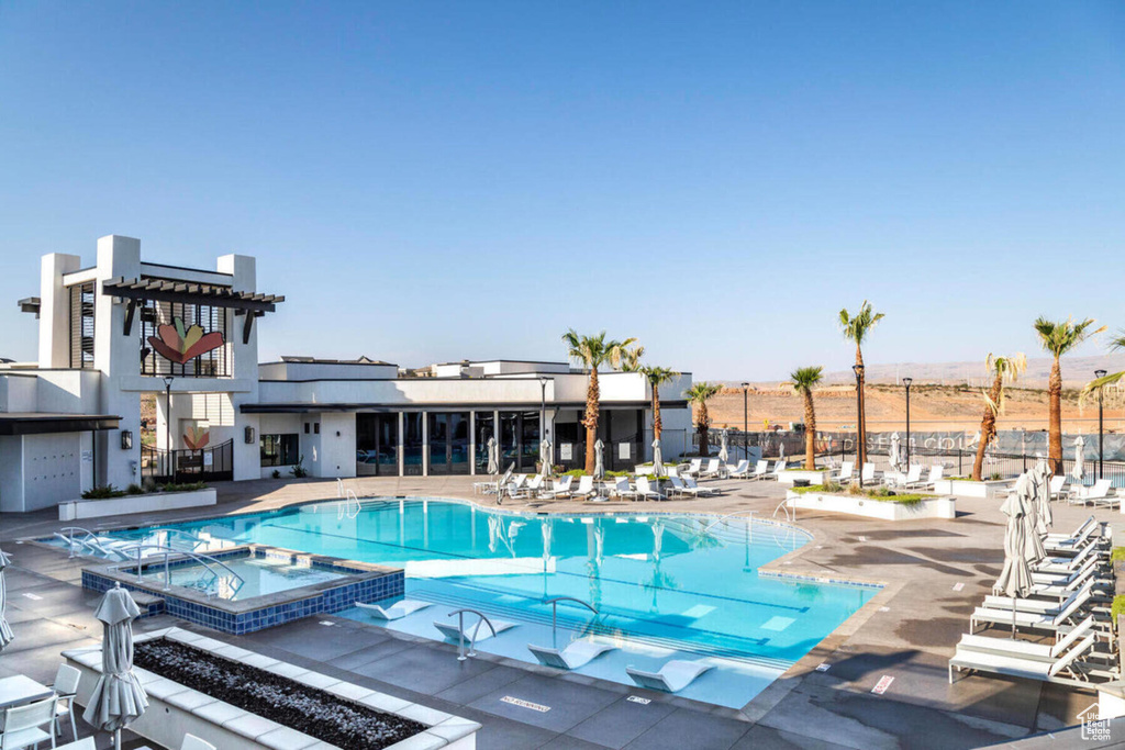 View of swimming pool featuring a community hot tub and a patio area