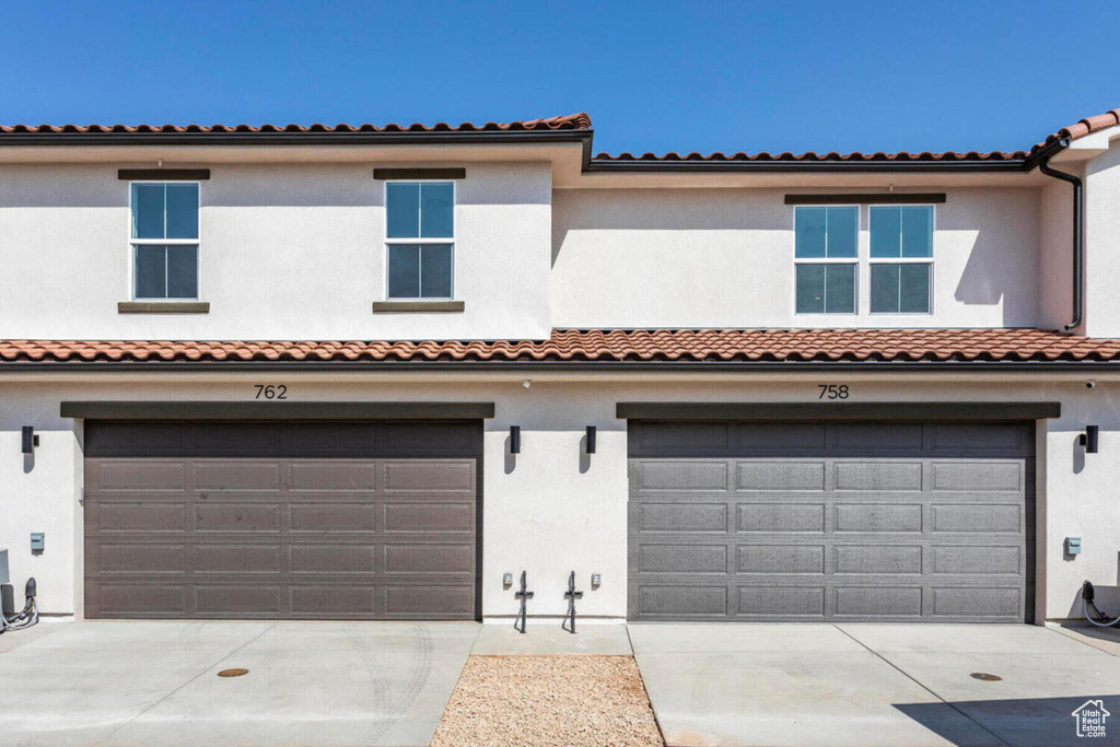 Mediterranean / spanish-style home with a garage