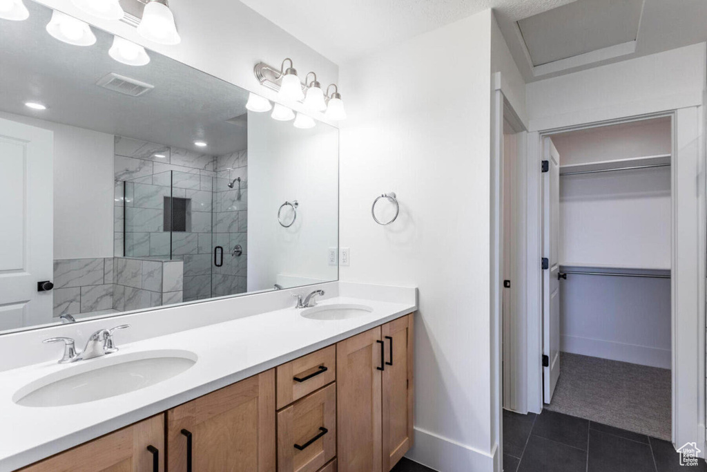 Bathroom with a shower with door, vanity, and tile patterned flooring