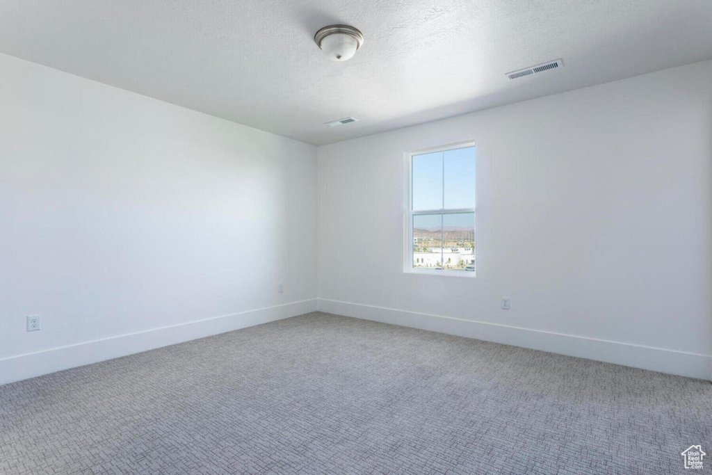 Unfurnished room featuring carpet and a textured ceiling