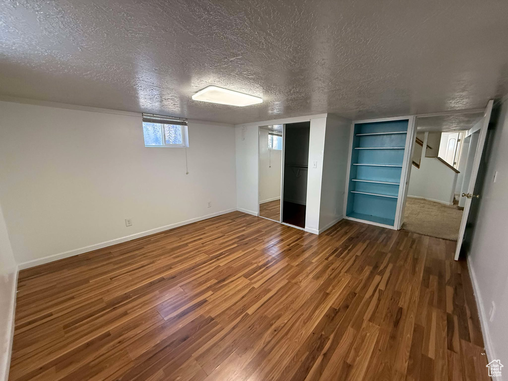 Unfurnished bedroom featuring a closet, hardwood / wood-style floors, and a textured ceiling