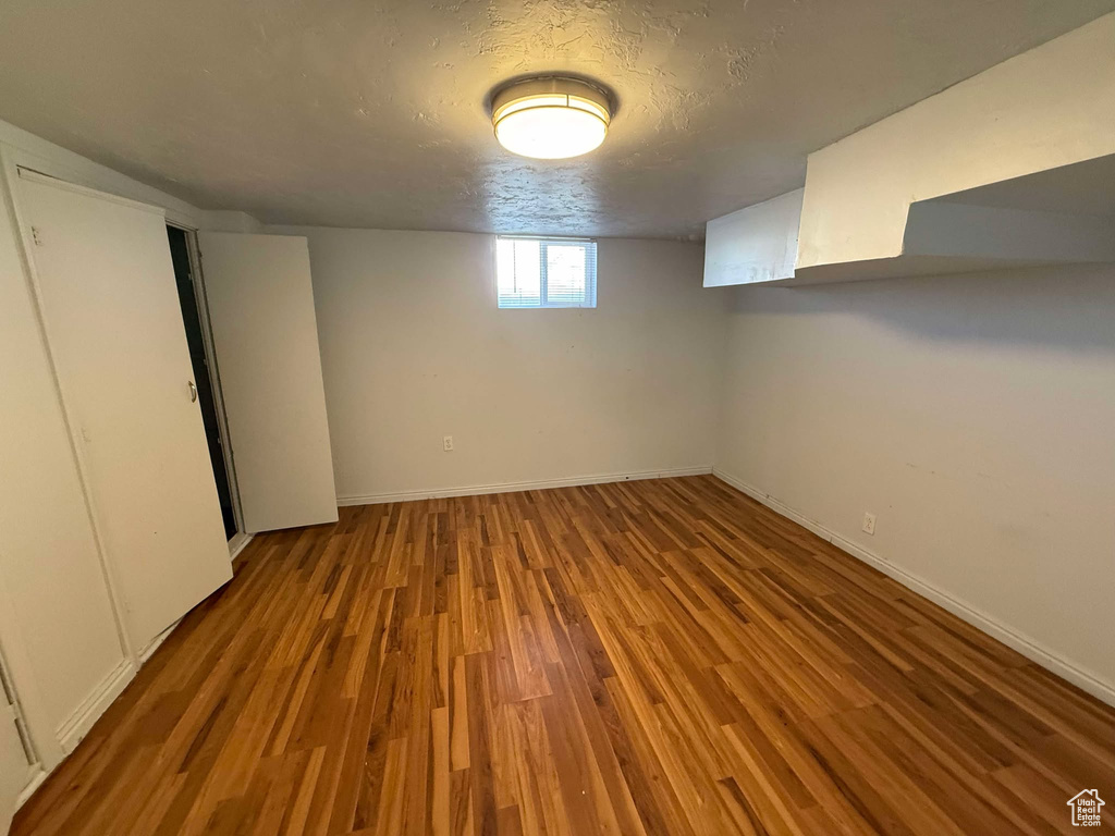 Basement featuring light hardwood / wood-style flooring and a textured ceiling