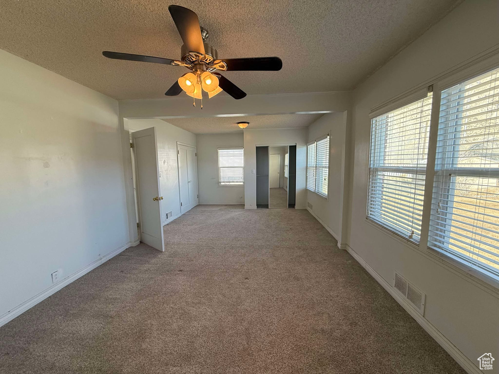 Spare room featuring light carpet and a textured ceiling