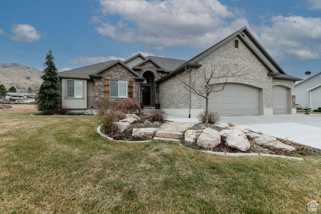 View of front of home with a garage and a front lawn