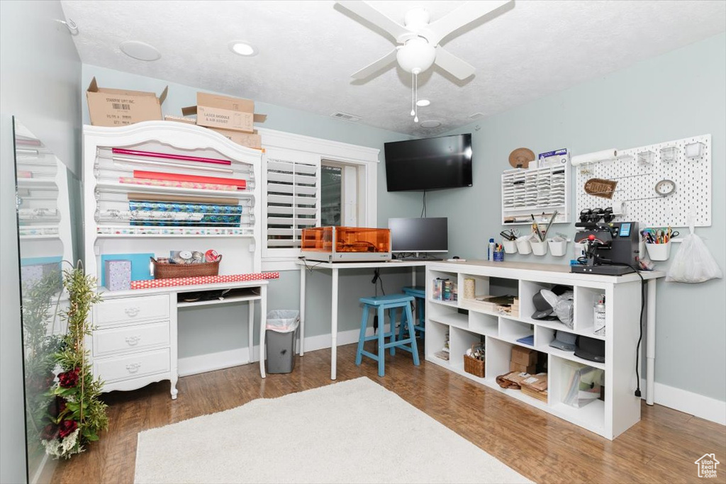 Home office with hardwood / wood-style floors and ceiling fan