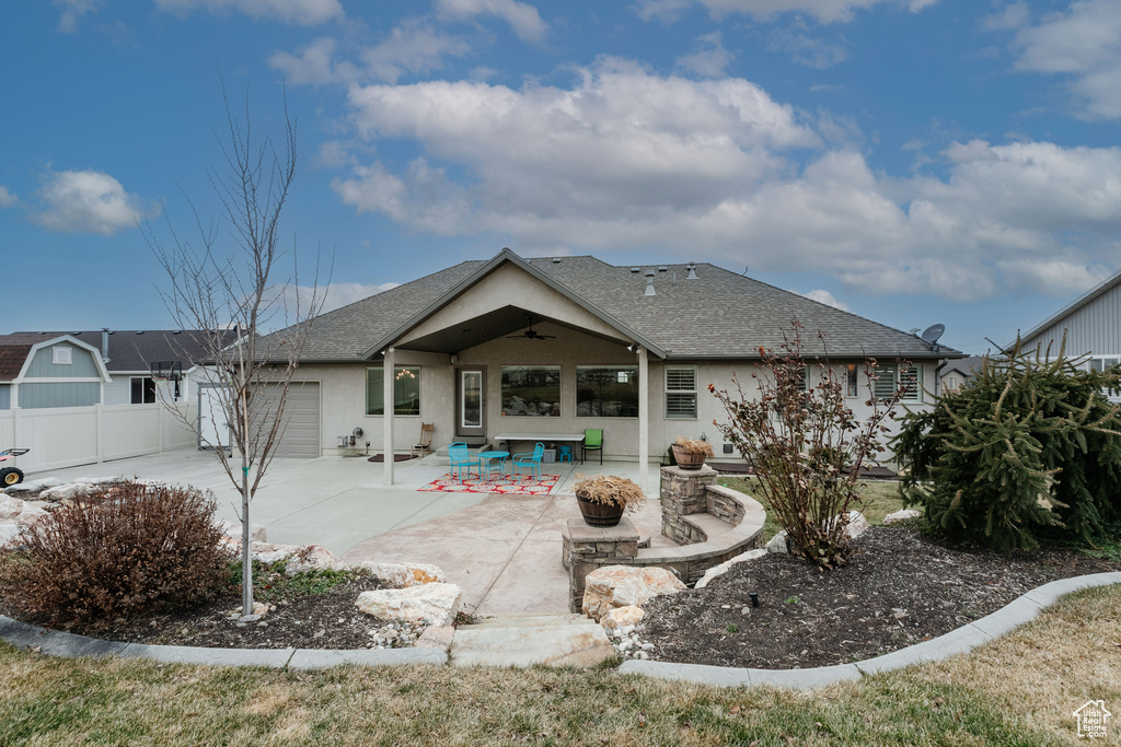 Rear view of property featuring a garage, a patio, and ceiling fan