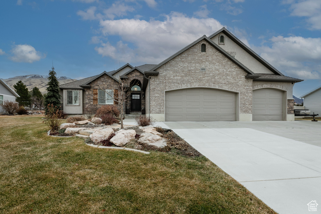 View of front of property with a garage and a front lawn