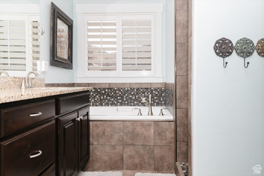 Bathroom with vanity and a relaxing tiled tub