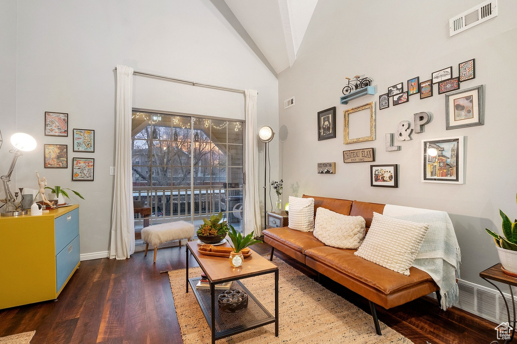 Living area featuring dark wood-type flooring and high vaulted ceiling