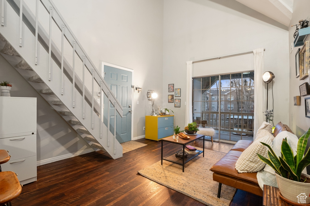 Living room featuring dark hardwood / wood-style flooring and a towering ceiling