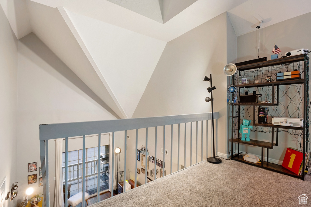 Hallway with carpet floors and vaulted ceiling