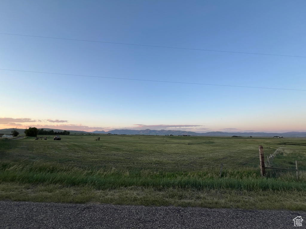 Yard at dusk with a rural view and a mountain view