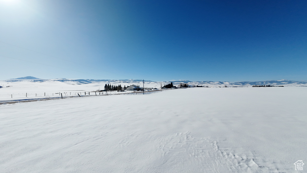 Yard covered in snow with a mountain view