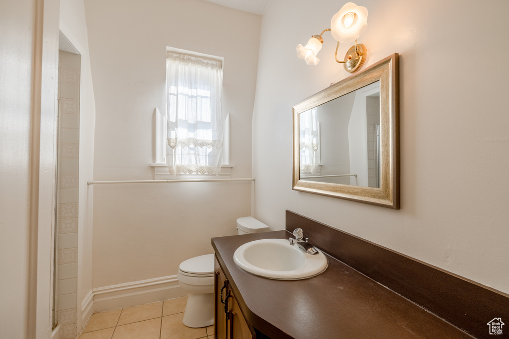 Bathroom featuring walk in shower, tile patterned floors, toilet, and vanity