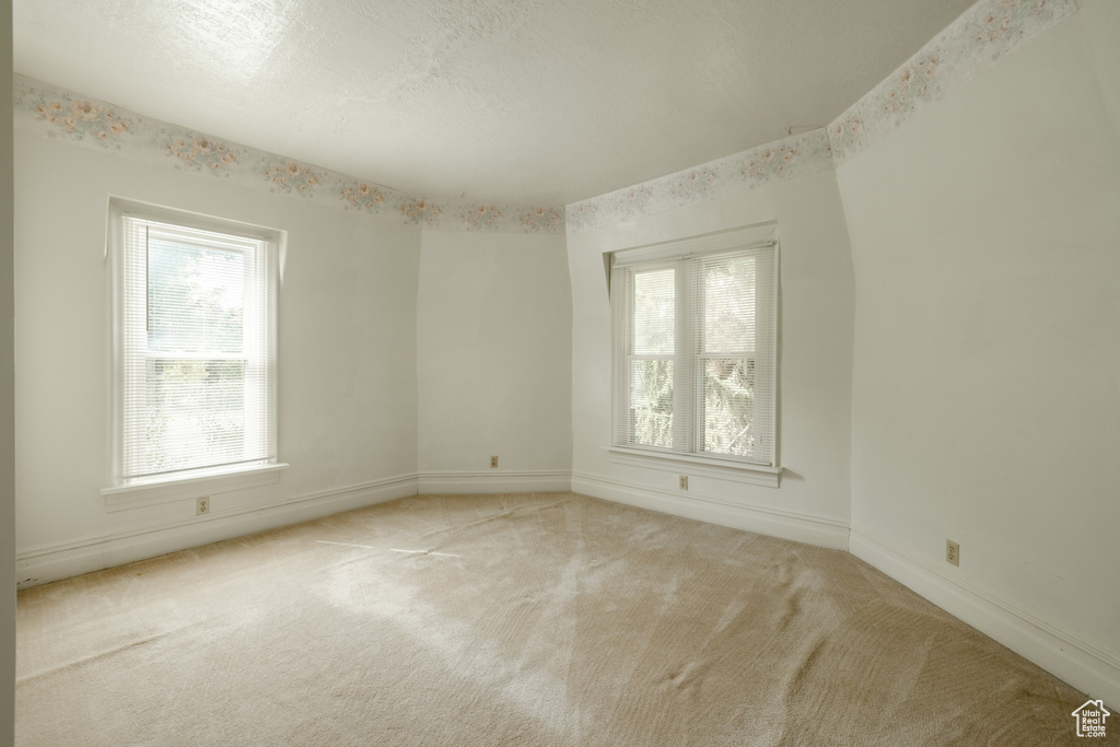 Carpeted empty room with plenty of natural light and a textured ceiling