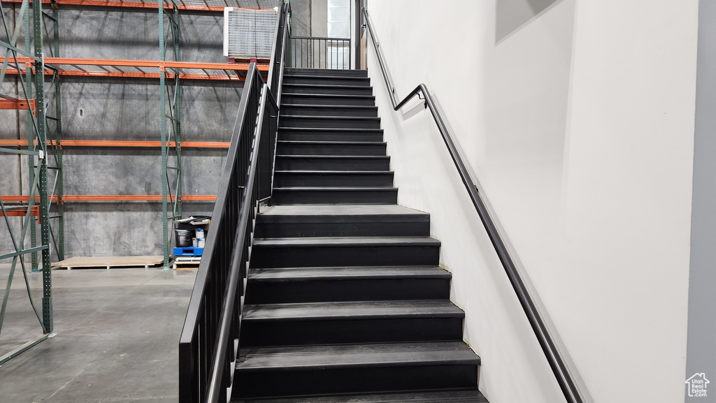 Staircase featuring concrete flooring