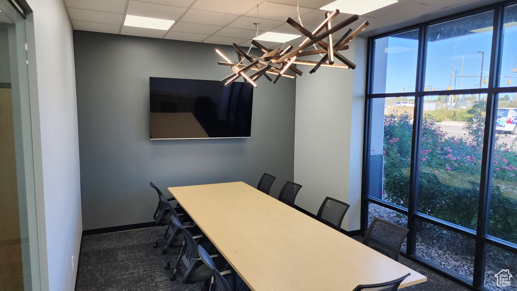 Unfurnished dining area featuring a paneled ceiling and a notable chandelier