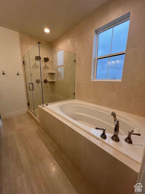 Bathroom with independent shower and bath and tile walls