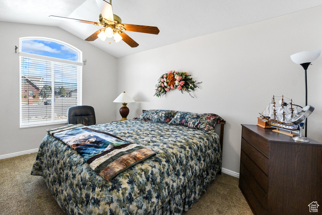 Carpeted bedroom featuring lofted ceiling and ceiling fan