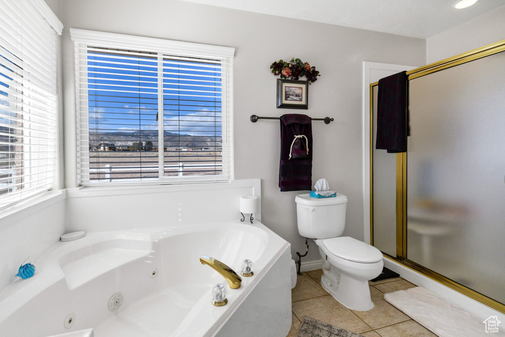 Bathroom with tile patterned flooring, independent shower and bath, and toilet