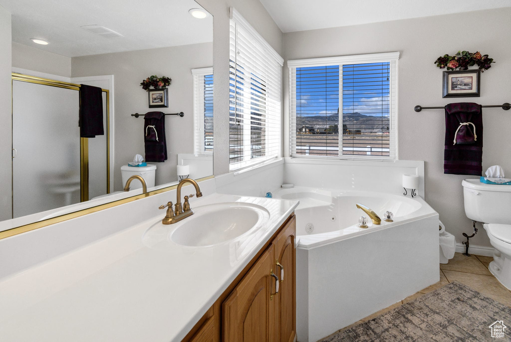 Full bathroom with tile patterned flooring, vanity, independent shower and bath, and toilet