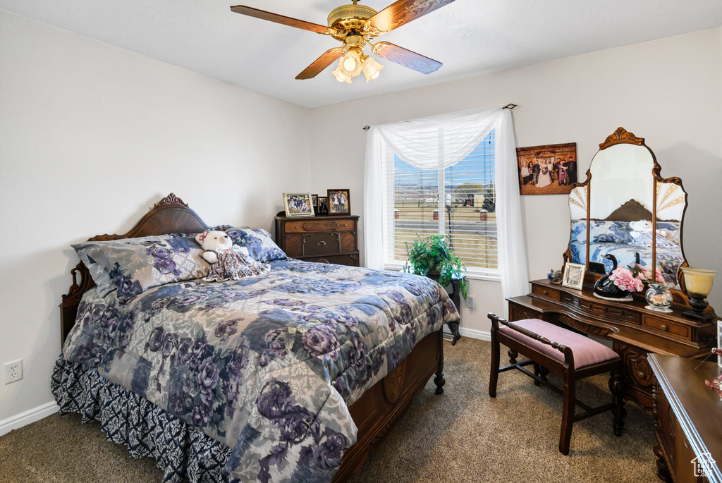 Carpeted bedroom featuring ceiling fan