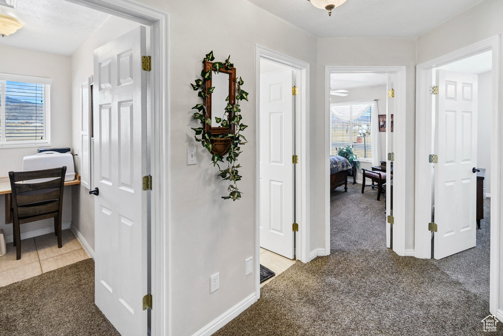 Hallway featuring dark colored carpet